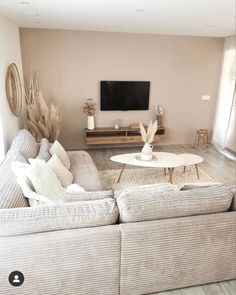 a living room filled with furniture and a flat screen tv mounted on the wall above it