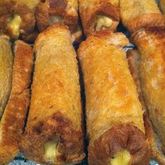 several pieces of bread with cheese and meat in them sitting on a table next to each other