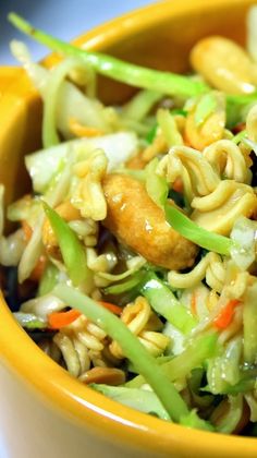 a yellow bowl filled with noodles and vegetables