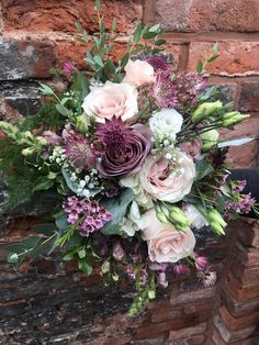 a bouquet of flowers sitting on top of a brick wall