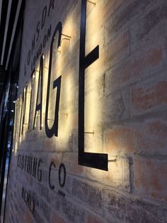 an illuminated sign on the side of a building that reads flat, pinned lettering