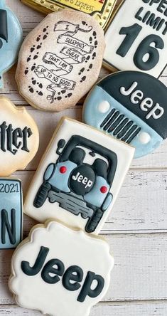 decorated cookies with jeep and jeep decals on top of white wood planks in the shape of cars