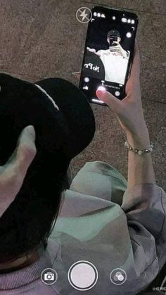 a person holding up a cell phone to take a selfie with her hat on