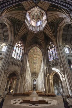 the inside of a cathedral with pews and stained glass windows