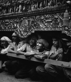 black and white photograph of men sitting in the back of a truck