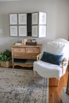 a white chair sitting in front of a wooden dresser