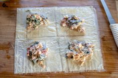 four square pieces of food on top of a wooden table