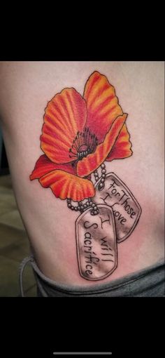 a woman's stomach with an orange flower and two tags attached to the side