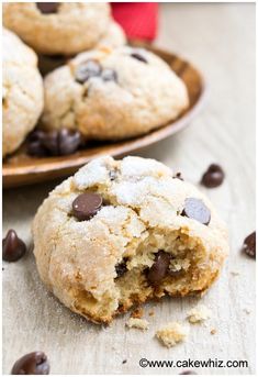 two chocolate chip cookies on a plate with one broken in half