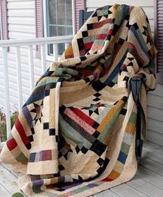 a quilted blanket sitting on the side of a porch next to a sign that says roscoe