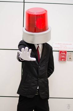 a man wearing a suit and tie with a red light on top of his head