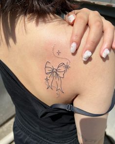 a woman with a bow tattoo on her back shoulder and right side ribcage