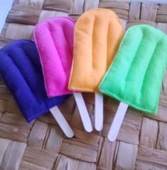 four different colored toothbrushes sitting on top of a wicker mat