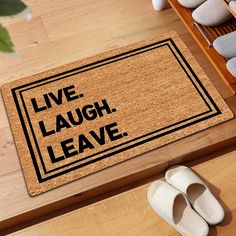 a door mat with the words live laugh leave on it next to shoes and slippers