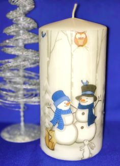 a frosty candle with two snowmen on it