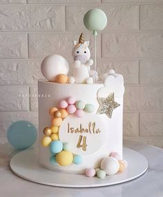 a birthday cake decorated with balloons and a unicorn