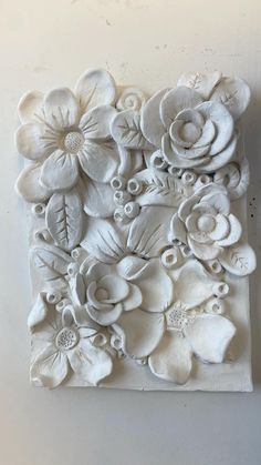 a white wall hanging with flowers on it