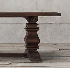 an old wooden table sitting in front of a white wall