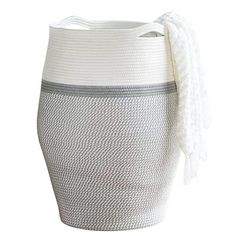 a white and grey basket with handles on the bottom, sitting against a white background