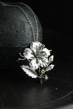 ITEM DESCRIPTION: The size H 45 mm x W 40 mm Weight - 6 g. You can buy it with the chain or without. The chain gently passes through a large enough loop behind the flower. This is really luxury floral pendant - Hibiscus flower. I made it of sterling silver, garnet, and peridot. But I can make it with another stone - just write me and we will discuss your custom order. The parcel will be sent 1-2 days after payment. Delivery usually takes 10-21 days. But in the period from December to February th Sterling Silver Flower Pendant Jewelry, Silver Sterling Flower Pendant Necklace, Silver Sterling Silver Flower Pendant Necklace, Silver Sterling Silver Pendant Flower Necklace, Silver Flower Pendant Jewelry, Sterling Silver Flower Pendant Necklace, Silver Flower Pendant Necklace, Unique Silver Flower-shaped Jewelry, Ursula Jewelry