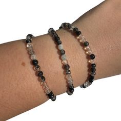 This listing is for one (1) black tourmaline in quartz round bracelet. These are stock photos in which you will be hand selected a bracelet. These are one size: "one size fits all" These are best suited for wrists measuring 5.5-7 inches in diameter. They do stretch quite a bit past that as well (if needed). (I have quite small wrists and they fit me fine, they are not too loose though; my wrists are shown in the picture). They are strung on elastic string in order to fit almost any wrist size! These bracelets are very stretchy!  Chip Style: these are tumbled, smooth stones but have an organic shape.  Stone size: 4mm Each order is packaged with love and care. If you have any questions feel free to message me! Black Tourmaline Bracelet, Round Bracelet, Tourmaline Quartz, Tourmaline Bracelet, Rutile Quartz, Bracelet Dainty, Quartz Bracelet, Black Tourmaline, Organic Shapes