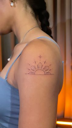 a woman with a sun tattoo on her shoulder