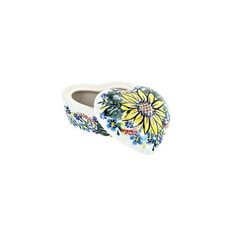 a white and yellow flowered shoe with blue flowers on the bottom, sitting in front of a white background