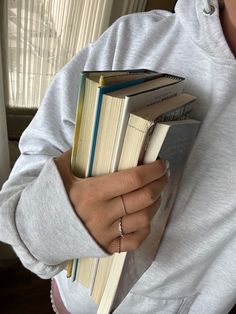 a woman holding two books in her hands