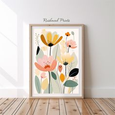 an art print with colorful flowers on it in a wooden frame against a white wall