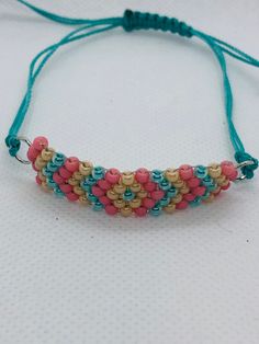 This beadwork project is a friendship design. This is done with size 8/0 Miyuki glass seed beads. It is made adjustable with nylon cord and will fit any size wrist.  If you would like this bracelet done in a different size or colors, let me know and I'll set up a listing for that.  You are purchasing this actual bracelet. Adjustable Pink Friendship Bracelets With Spacer Beads, Pink Beaded Braided Bracelet For Friendship, Pink Bohemian Beaded Bracelets With Adjustable Cord, Bohemian Pink Beaded Bracelets With Adjustable Cord, Pink Friendship Bracelets With Spacer Beads, Turquoise Braided Bracelets With Colorful Beads For Friendship, Turquoise Round Beads Friendship Bracelets, Friendship Design, Bead Friendship Bracelet