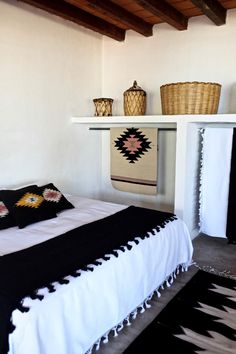 a black and white bed in a room with wooden beams on the ceiling above it