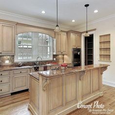 a large kitchen with an island in the middle and cabinets on both sides, along with wooden flooring