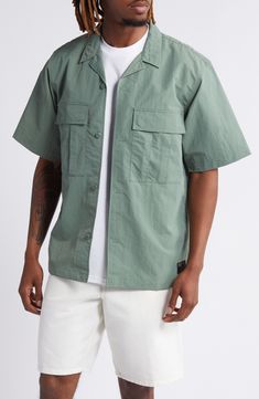 A loose fit gives you room to move comfortably in this workwear-inspired shirt made from durable, adventure-ready nylon ripstop. 29 1/2" length, 44" chest (size medium) Front button closure Notched collar Short sleeves Chest snap-flap pockets 100% nylon Machine wash, line dry Imported Green Shirt With Pockets For Outdoor Activities, Casual Short Sleeve Shirt With Pockets For Outdoor, Khaki Camp Shirt With Relaxed Fit And Camp Collar, Khaki Collared Camp Shirt For Outdoors, Khaki Camp Shirt With Relaxed Fit, Khaki Cotton Camp Shirt For Outdoor, Khaki Relaxed Fit Shirt For Outdoor, Outdoor Khaki Relaxed Fit Shirt, Outdoor Khaki Cotton Camp Shirt