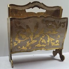 an old wooden bed with gold paint on it