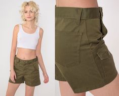 Vintage 70s Boy Scout shorts in olive green with patch pockets and a high waist. Please see measurements and condition below. Every garment we sell is authentic vintage! You will receive the exact item photographed. Condition: Very good vintage with light general wear. Best fits women's: Small. Boy's cut, so slim in the hip compared to the waist. Tag: ILGWU Material:  Feels like Cotton MEASUREMENTS Taken from seam to seam while the garment is lying flat. Double the armpit, waist, and hips For re Vintage Cotton Khaki Shorts, Vintage Cotton Cargo Shorts For Summer, Vintage Cargo Bottoms For Summer, Vintage Summer Bottoms With Cargo Pockets, Green Military Style Short Length Shorts, Vintage Cotton Shorts With Cargo Pockets, Military Style Green Shorts, Vintage Summer Cargo Shorts With Pockets, Green Military Style Shorts