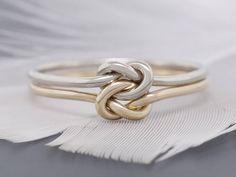 two tone gold and silver rings on white feathers