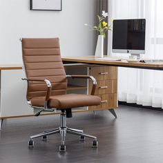 a brown office chair sitting in front of a computer desk