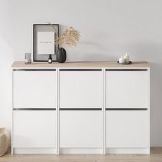 an empty room with a white cabinet and some candles on the shelf next to it