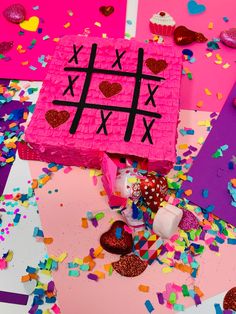 a tic - tac - toe cake surrounded by confetti and sprinkles