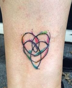 a tattoo on the leg of a woman with two intertwined hearts in different colors