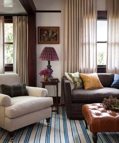 a living room with two couches, a chair and a table in front of the window