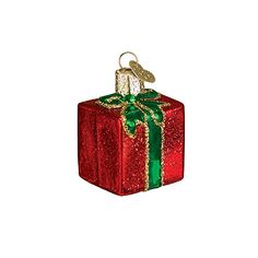 a red gift box with a green ribbon and a gold bird on it's top