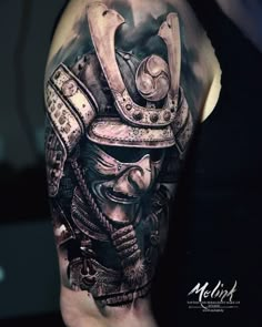 a man with a tattoo on his arm is wearing a helmet and holding a knife