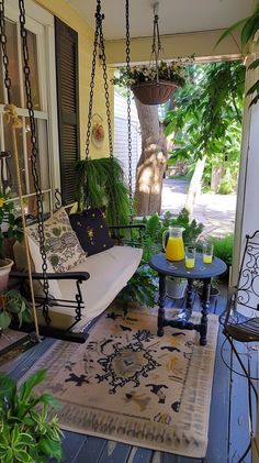 Serene porch retreat with white swing, decorative pillows, greenery, and cozy atmosphere for outdoor relaxation.