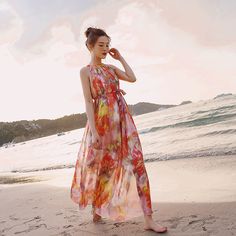 The Floral Printed Halter Neck Sleeveless Belted Maxi Dress boasts a vibrant floral pattern and a chic halter neckline. Its sleeveless design, accompanied by a matching belt, enhances the waistline, creating a graceful and summery silhouette perfect for various occasions. Chic Orange Sleeveless Beach Dress, Summer Party Floral Halter Neck Dress, Pink Floral Print Sleeveless Dress For Beach, Pink Floral Print Sleeveless Dress For The Beach, Orange Halter Neck Sleeveless Dress For Summer, Orange Halter Neck Sleeveless Dress For Vacation, Pink Halter Dress For Beach Season, Pink Halter Neck Dress For Beach Season, Chic Orange Halter Dress For Summer