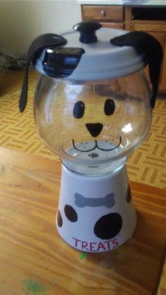 a glass bowl with a dog's head in it on top of a wooden table