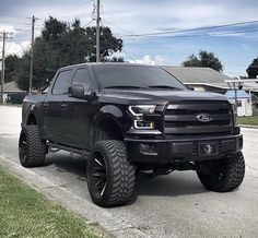 a black truck is parked on the side of the road