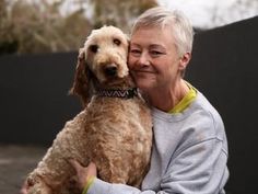 a woman holding a dog in her arms