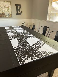 a dining room table with black chairs and a white table cloth on top of it