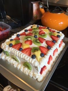 a cake with fruit on it sitting on top of a stove